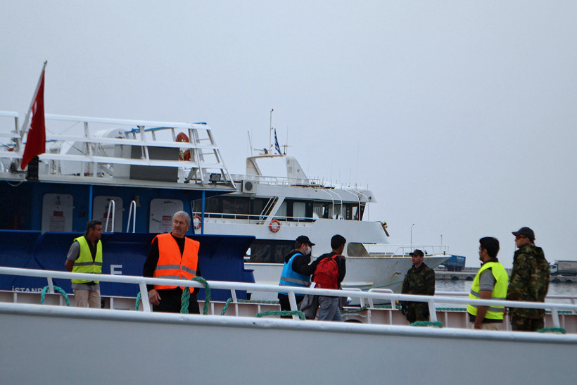 Frontex-Mitarbeiter eskortieren Flüchtlinge an Bord eines Bootes auf Insel Lesbos (dpa)